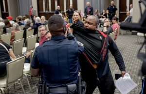 Momentos selvagens manifestantes bateu com uma arma de Stan enquanto explodem no caos na prefeitura de Marjuri Taylor Green