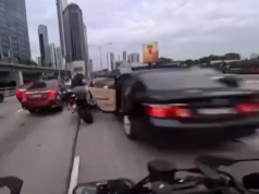 Momento chocante em que um motociclista é atropelado por um motociclista quando uma criança abre a porta do carro no momento em que ele passa, fazendo-o voar