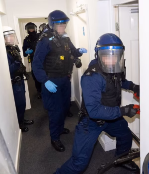 106368439-15558007-Police_officers_smash_into_the_home_of_a_16_year_old_suspected_o-m-9_177125716251.avif
