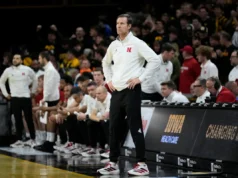 O técnico do Nebraska, Fred Hoiberg, rouba o telefone de um torcedor de Iowa durante uma tempestade na quadra pós-jogo