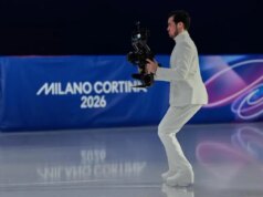 A ex-dançarina de gelo patina no gelo da pista olímpica como operadora de câmera