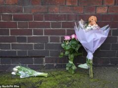 Pessoas em luto deixam brinquedos e flores no local onde uma menina de 18 dias caiu de casa para a morte – como mulher, 43 anos, presa por ‘assassinato’