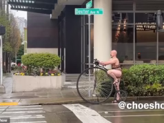 Chita careca vista andando de monociclo por Seattle em tempo chuvoso