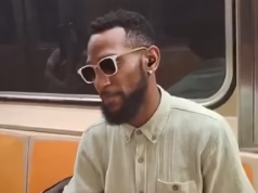 Homem bem vestido de Nova York faz ameaças desagradáveis ao passageiro do metrô depois de dizer-lhe para não tocar música nos alto-falantes