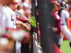 Coroas de brócolis e vacas empalhadas no Women’s College World Series: por que os abrigos de softball são os melhores no baile universitário