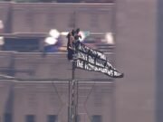 Cenas selvagens da dupla mascarada levando o Empire State Building ao topo e hasteando bandeiras de amor e paz