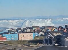 Momento em que um enorme iceberg vira, provocando ondas semelhantes a um tsunami na cidade costeira da Groenlândia
