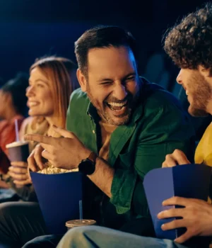 cheerful-man-laughing-watching-movie-in-theater.webp