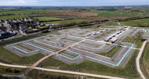 Um enorme estacionamento de £ 32 milhões que está vazio há dois anos teve sua reabertura adiada porque a estrada de ligação ainda não foi concluída.