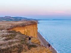 Apesar das precauções de segurança na queda de rochas, um adolescente arrisca sua vida ao posar para uma foto na beira de um penhasco em ruínas de 45 metros que ficou famoso por Broadchurch