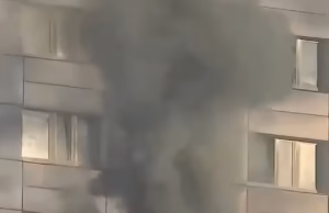 Mulher balança no 11º andar de um prédio em chamas antes de pular ousadamente para um lugar seguro em um momento de arrepiar os cabelos