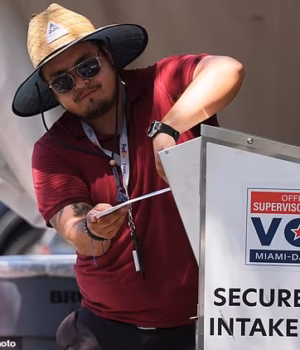 110827437-16077057-An_election_worker_places_a_vote_by_mail_ballot_into_a_secure_bi-a-1_178760898039.avif