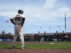 O técnico da terceira base do Giants, Ron Watts, sai enquanto troca cartas de escalação antes do jogo 1 de uma partida dupla contra os D-backs.