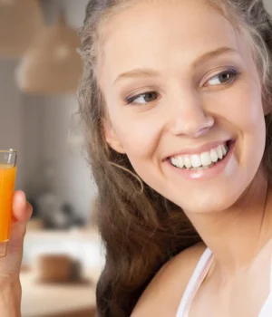 young-happy-woman-drinking-orange-juice.webp