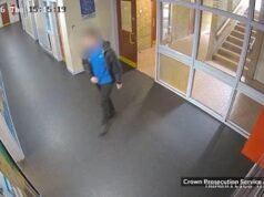 Momento em que o professor sai da sala de aula com uma faca na mão depois que um estudante o esfaqueia na cabeça