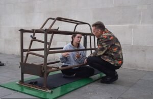 Chris Packham se junta a uma mulher que se trancou em uma jaula de porcos por três semanas em Trafalgar Square para protestar contra a pecuária industrial