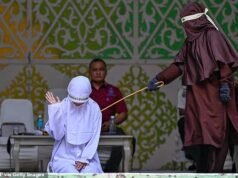 Uma mulher cai após ser açoitada por fazer sexo fora do casamento, em violação da lei sharia na Indonésia